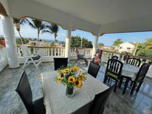 a table with a vase of sunflowers on a porch at Villa Hermosa1 / Piscina in San Felipe de Puerto Plata
