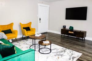 een woonkamer met een bank, 2 stoelen en een tv bij Walk to AT&T Stadium , Globelife from Cozy 2bd/ba Apartment in Arlington
