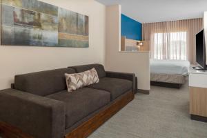 a living room with a couch and a bed at SpringHill Suites by Marriott Baton Rouge South in Baton Rouge