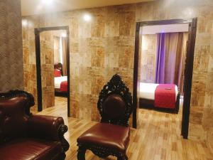 a room with a mirror and a chair and a bed at HYDERS PARK- THE LUXURY HOTEL in Kodaikānāl