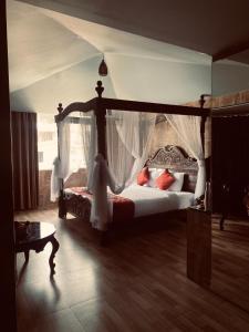 a bedroom with a canopy bed with white curtains at HYDERS PARK- THE LUXURY HOTEL in Kodaikānāl