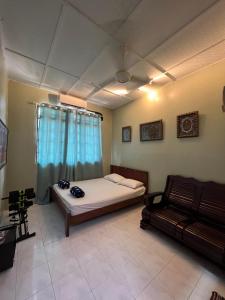 1 dormitorio con cama y sofá en Bagan Lalang Homestay Sepang, en Kampong Bagan Lalang