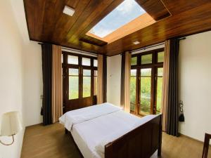 ein Schlafzimmer mit einem Bett und einem großen Fenster in der Unterkunft La Seran Eco Resort in Bandarawela