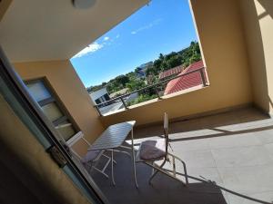 un balcone con 2 sedie e una grande finestra di Vaea's Place a Papeete