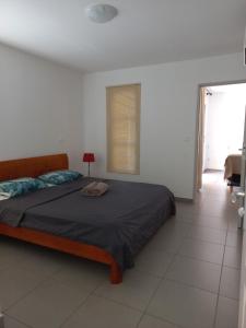 a bedroom with a bed and a table and a window at Vaea's Place in Papeete