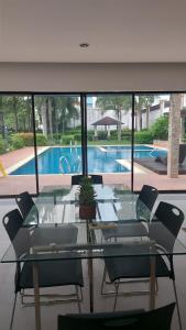 a glass table and chairs in front of a swimming pool at Minimalist Condo Studio City Tower 2 Filinvest Alabang Muntinlupa in Manila