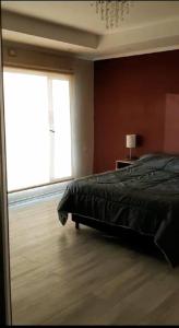 Un dormitorio con una cama y una ventana grande. en Moderno Duplex 2 - Alquiler en Comodoro Rivadavia, en Comodoro Rivadavia