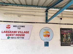 a sign for a library village guest house on a wall at Langkawi-Village Mix Dormitory in Pantai Cenang
