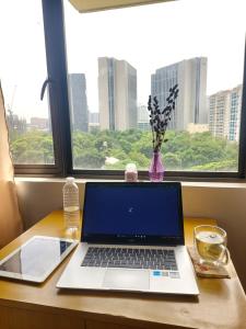 a laptop computer sitting on a desk in front of a window at Minimalist Condo Studio City Tower 2 Filinvest Alabang Muntinlupa in Manila