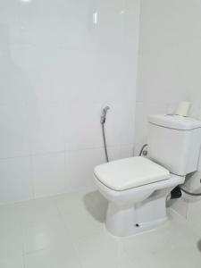 - une salle de bains avec toilettes dans une chambre blanche dans l'établissement Sunrise Cottage, à Sigirîya