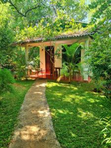 une petite maison avec un chemin menant à celle-ci dans l'établissement Sunrise Cottage, à Sigirîya