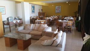 uma sala de estar com sofás e mesas e um restaurante em Pissouriana hotel Apartments em Pissouri
