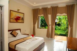Schlafzimmer mit einem Bett und einem Fenster in der Unterkunft PHƯƠNG NHUNG HOTEL in Phan Thiet