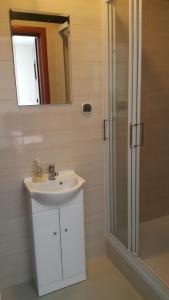 a bathroom with a sink and a shower and a mirror at Sleep In Łomża in Łomża