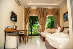 1 Schlafzimmer mit 2 Betten, einem Schreibtisch und einem TV in der Unterkunft PHƯƠNG NHUNG HOTEL in Phan Thiet
