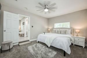 a bedroom with a white bed and a ceiling fan at Fun City Haven Spacious Retreat in Fresno in Fresno
