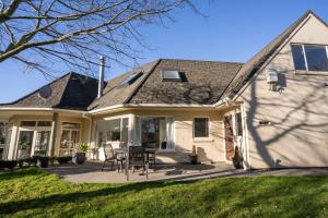 una casa bianca con un tavolo e sedie su un patio di Country Apartment a Paraparaumu