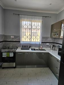 une cuisine avec une cuisinière et une fenêtre dans l'établissement Villa Serene, à Lusaka
