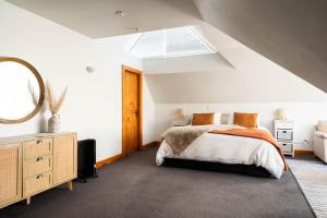 Dormitorio en el ático con cama y espejo en Country Apartment en Paraparaumu