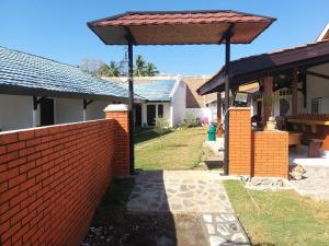 a house with a brick wall and a roof at Aipayung Homestay 