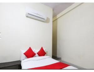 una camera da letto con un letto con cuscini rossi di Apeksha Hotel, Sanchi a Sānchi