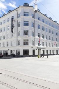 un grand bâtiment blanc au coin d'une rue dans l'établissement Absalon Hotel, à Copenhague