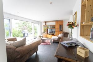 un soggiorno con un divano e un tavolo di Chasa Emerita Moderne 3,5-Zimmer Terrassenwohnung mit Panoramablick a Scuol