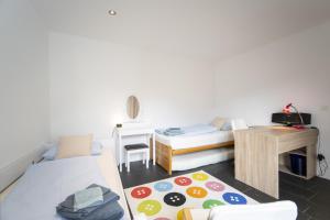 Camera con 2 letti, scrivania e tavolo. di Chasa Emerita Moderne 3,5-Zimmer Terrassenwohnung mit Panoramablick a Scuol