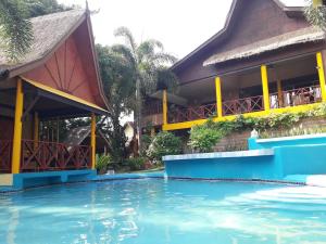 een resort met een zwembad voor een gebouw bij Old Tree's House ThaTon in Mae Ai