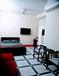sypialnia z łóżkiem, kanapą i telewizorem w obiekcie Hotel Shree Ram SIA Residency w mieście Gaja