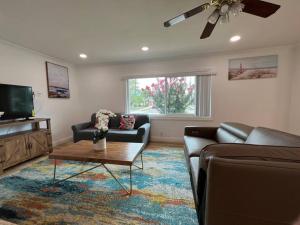 a living room with a couch and a tv at Modern 3 King Beds, Beautiful Large Backyard, WFH, Long Stays, Waterfall, WI-FI, FWY, 25 mins to Beach in Thousand Oaks