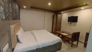a bedroom with a bed and a desk and a television at Shimla Royale - Near Mall Road Free Pickup From Railway Station Shimla in Shimla