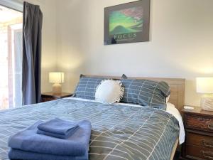 a bedroom with a blue bed with two blue pillows at Inverloch Sands in Inverloch