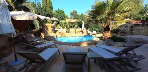 a pool with chairs and a table and an umbrella at The Red Farm Relais & Spa in LʼInglin