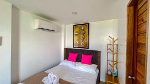 a bedroom with a bed with two pink pillows at Caliraya Heights Resorts and Events Place in Halang