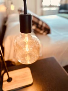 una lampada di vetro su un tavolo accanto a un letto di Hotel Malpensa INN Aereoporto a Tornavento