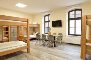 a room with a table and chairs and a bunk bed at Hostel & Pension Alte Brauerei in Eisenach