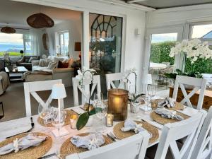 comedor con mesa y sillas blancas en Trem Ynys, en Pwllheli