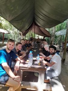 un grupo de hombres sentados en una mesa de picnic en Mobylette Sai Gon, en Ho Chi Minh