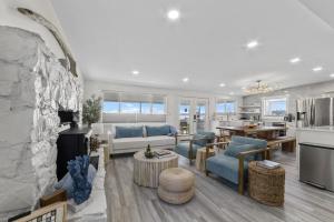 a living room with a stone fireplace and a kitchen at New DRIFTWOOD SHORES ROAD HOUSE CAMANO in Driftwood Shores