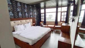sypialnia z łóżkiem w pokoju z oknami w obiekcie Shimla Royale - Near Mall Road Free Pickup From Railway Station Shimla w mieście Shimla