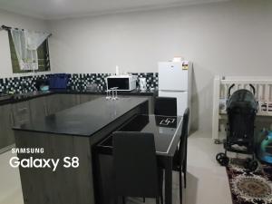 a kitchen with a black counter top and a refrigerator at Two Bedroom Holiday Home- Olosara Sigatoka Guest House in Singatoka