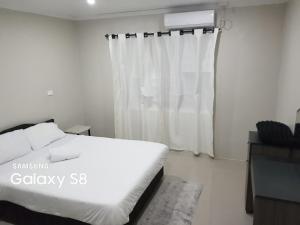 a bedroom with a white bed and a window at Two Bedroom Holiday Home- Olosara Sigatoka Guest House in Singatoka