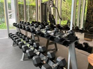 a gym with rows of dumbbells on a table at Thonglor Modern studio condo in Khlong Toei