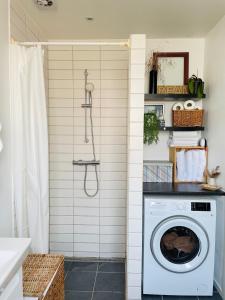 a washing machine in a bathroom with a shower at Your Perfect Aarhus Staycation in Aarhus