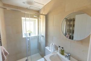 a bathroom with a shower and a sink and a mirror at CHARLES STREET - Cottage at the edge of the Peak District National Park, Buxton in Buxton