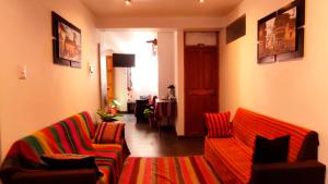 a living room with a couch and two chairs at Qolmay Hostel Cusco in Cusco