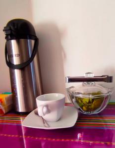 una cafetera y una taza sobre una mesa en Qolmay Hostel Cusco en Cusco