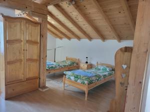 a bedroom with two beds and a wooden ceiling at Къща за гости - Еделвайс, гр. Габрово in Gabrovo