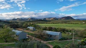 an aerial view of a farm with mountains in the background at Thabile Lodge in Oudtshoorn